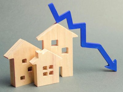 Wooden house cut outs with blue down pointing arrow