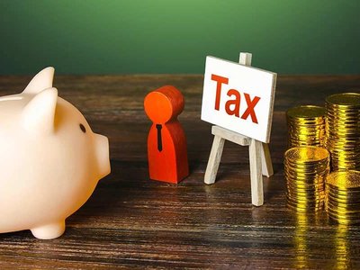 Piggybank with tax sign and stacks of coins