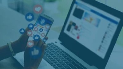 Person on laptop and phone with social media hearts and thumbs up graphics around it